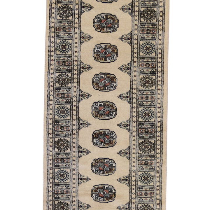 2'7" x 9'4" GOLD AND IVORY BOKARA GEOMETRIC PAKISTANI RUG