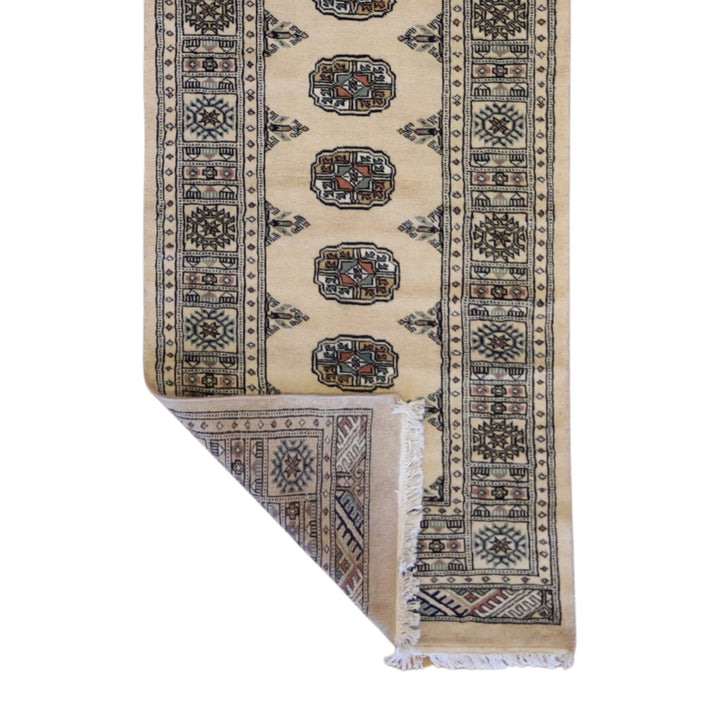 2'7" x 9'4" GOLD AND IVORY BOKARA GEOMETRIC PAKISTANI RUG